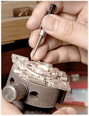 Watchmaker working on repair at desk.