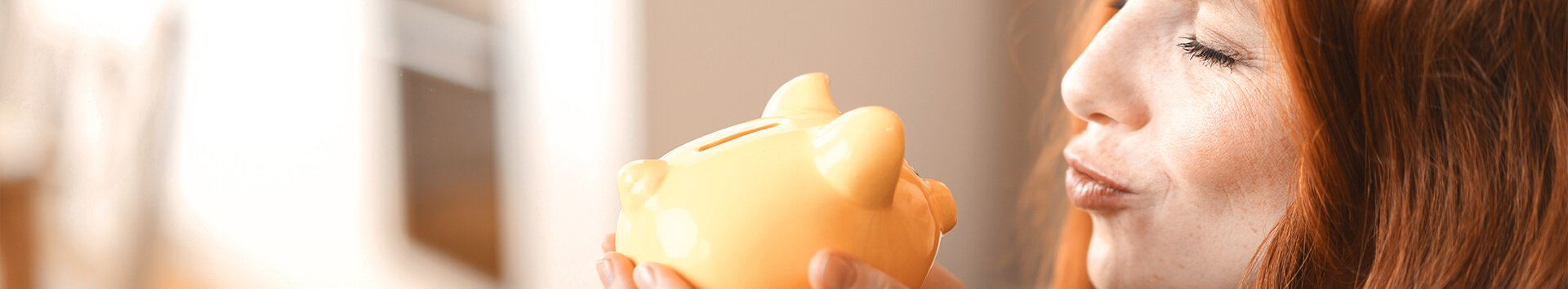 Woman adoring her yellow piggy bank.