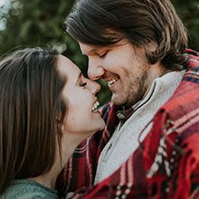 Headshot of young couple embracing.